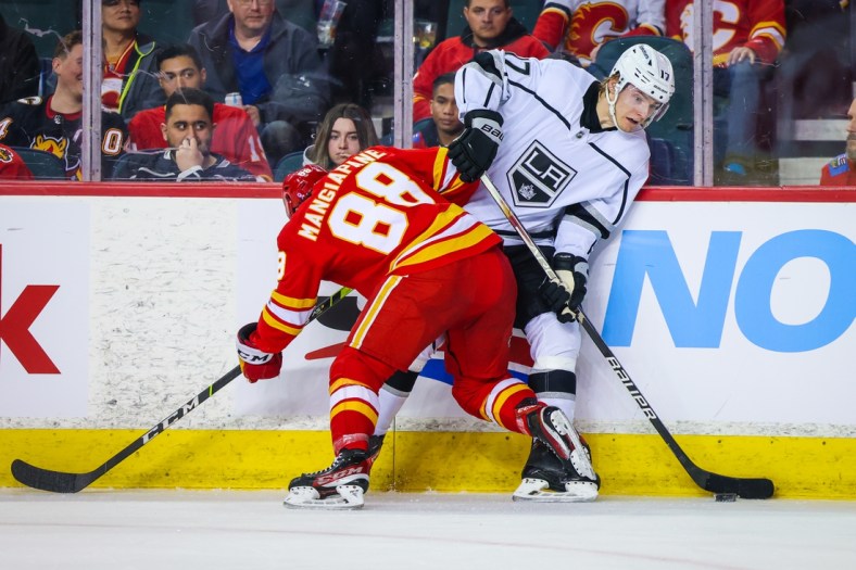 Mar 31, 2022; Calgary, Alberta, CAN; Los Angeles Kings center Lias Andersson (17) and Calgary Flames left wing Andrew Mangiapane (88) battle for the puck during the second period at Scotiabank Saddledome. Mandatory Credit: Sergei Belski-USA TODAY Sports