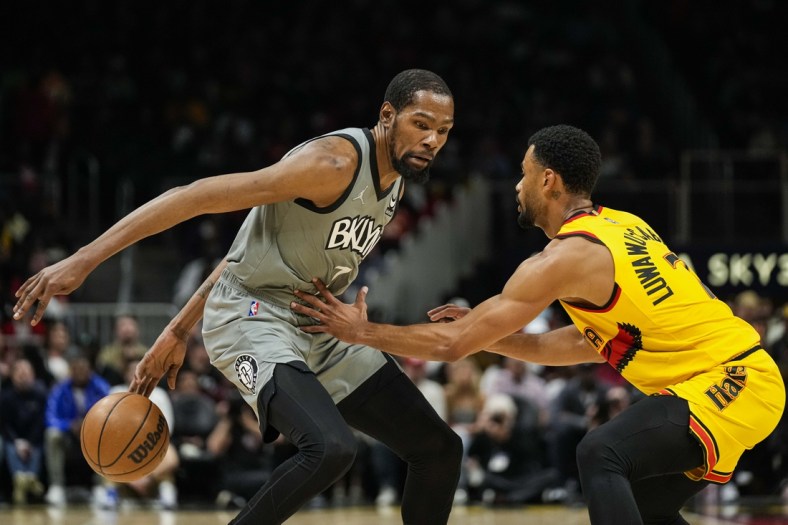 Apr 2, 2022; Atlanta, Georgia, USA; Brooklyn Nets forward Kevin Durant (7) controls the ball behind his back in front of Atlanta Hawks guard Timothe Luwawu-Cabarrot (7) during the first quarter at State Farm Arena. Mandatory Credit: Dale Zanine-USA TODAY Sports