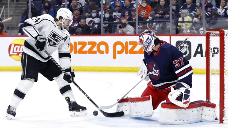 Apr 2, 2022; Winnipeg, Manitoba, CAN; Winnipeg Jets goaltender Connor Hellebuyck (37) blocks a shot by Los Angeles Kings center Phillip Danault (24) in the first period at Canada Life Centre. Mandatory Credit: James Carey Lauder-USA TODAY Sports