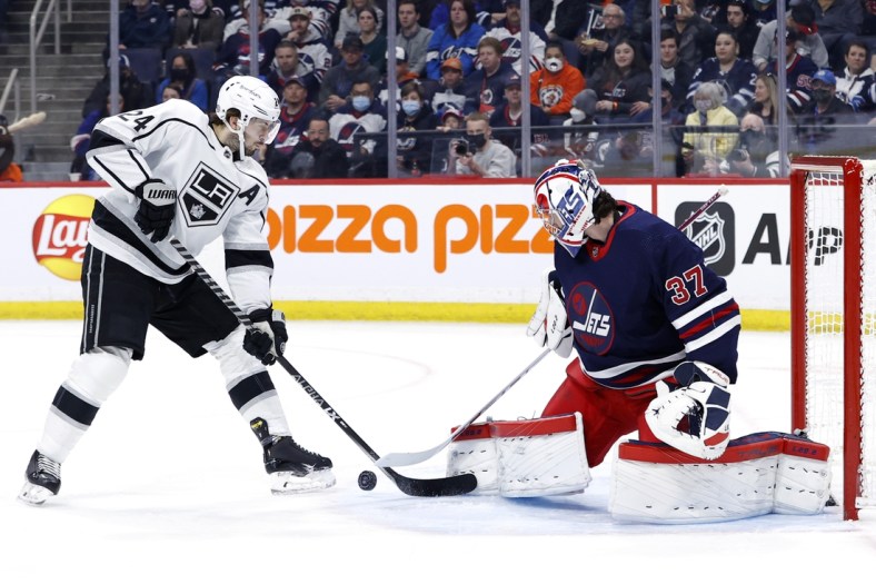 Apr 2, 2022; Winnipeg, Manitoba, CAN; Winnipeg Jets goaltender Connor Hellebuyck (37) blocks a shot by Los Angeles Kings center Phillip Danault (24) in the first period at Canada Life Centre. Mandatory Credit: James Carey Lauder-USA TODAY Sports