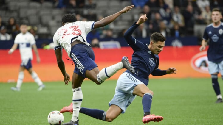 Apr 2, 2022; Vancouver, British Columbia, CAN;  Vancouver Whitecaps defender Javain Brown (23) and Sporting Kansas City forward Daniel Salloi (20) collide during the first half at BC Place. Mandatory Credit: Anne-Marie Sorvin-USA TODAY Sports
