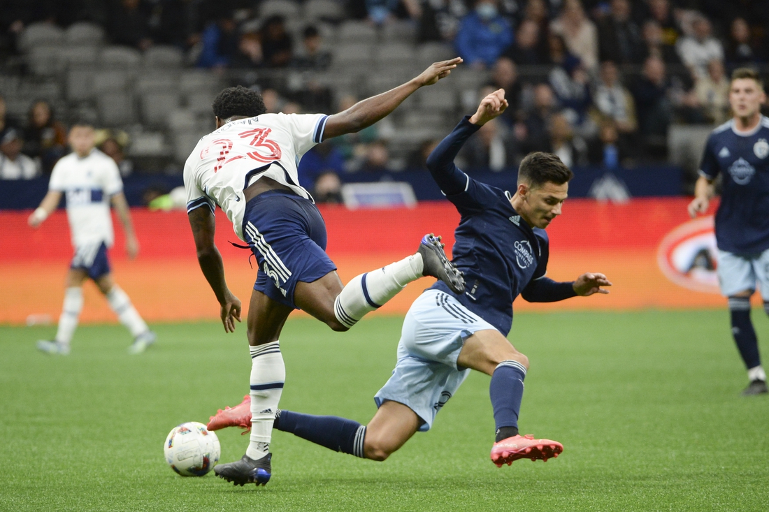 Apr 2, 2022; Vancouver, British Columbia, CAN;  Vancouver Whitecaps defender Javain Brown (23) and Sporting Kansas City forward Daniel Salloi (20) collide during the first half at BC Place. Mandatory Credit: Anne-Marie Sorvin-USA TODAY Sports