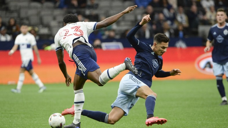 Apr 2, 2022; Vancouver, British Columbia, CAN;  Vancouver Whitecaps defender Javain Brown (23) and Sporting Kansas City forward Daniel Salloi (20) collide during the first half at BC Place. Mandatory Credit: Anne-Marie Sorvin-USA TODAY Sports