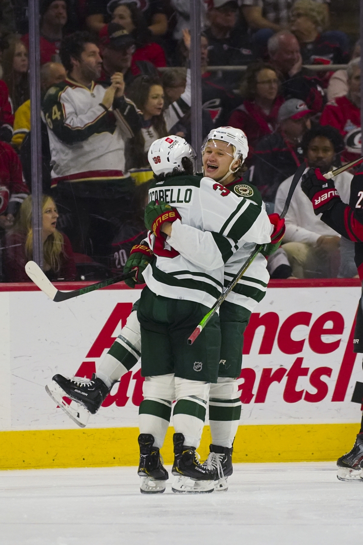 Apr 2, 2022; Raleigh, North Carolina, USA;  Minnesota Wild left wing Kirill Kaprizov (97) is congratulated after his goal by right wing Mats Zuccarello (36) against the Carolina Hurricanes during the third period at PNC Arena. Mandatory Credit: James Guillory-USA TODAY Sports