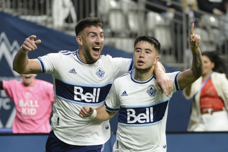 Apr 2, 2022; Vancouver, British Columbia, CAN;  Vancouver Whitecaps midfielder Ryan Raposo (27) celebrates his goal against Sporting Kansas City goalkeeper Tim Melia (29) (not pictured) with forward Lucas Cavallini (9) during the second half at BC Place. Mandatory Credit: Anne-Marie Sorvin-USA TODAY Sports