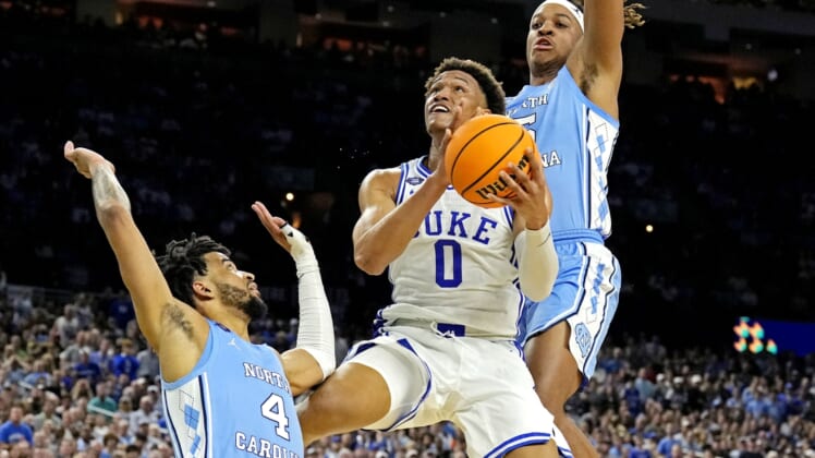 Apr 2, 2022; New Orleans, LA, USA; Duke Blue Devils forward Wendell Moore Jr. (0) drives to the basket against North Carolina Tar Heels guard R.J. Davis (4) and North Carolina Tar Heels forward Armando Bacot (5) during the second half in the 2022 NCAA men's basketball tournament Final Four semifinals at Caesars Superdome. Mandatory Credit: Robert Deutsch-USA TODAY Sports
