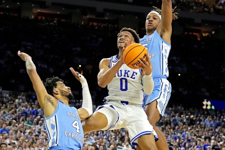 Apr 2, 2022; New Orleans, LA, USA; Duke Blue Devils forward Wendell Moore Jr. (0) drives to the basket against North Carolina Tar Heels guard R.J. Davis (4) and North Carolina Tar Heels forward Armando Bacot (5) during the second half in the 2022 NCAA men's basketball tournament Final Four semifinals at Caesars Superdome. Mandatory Credit: Robert Deutsch-USA TODAY Sports