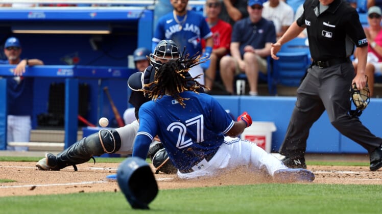 Apr 3, 2022; Dunedin, Florida, USA; Toronto Blue Jays first baseman Vladimir Guerrero Jr. (27) slides safe into home plate ahead of the throw to New York Yankees catcher Max McDowell (98) during the first inning during spring training at TD Ballpark. Mandatory Credit: Kim Klement-USA TODAY Sports
