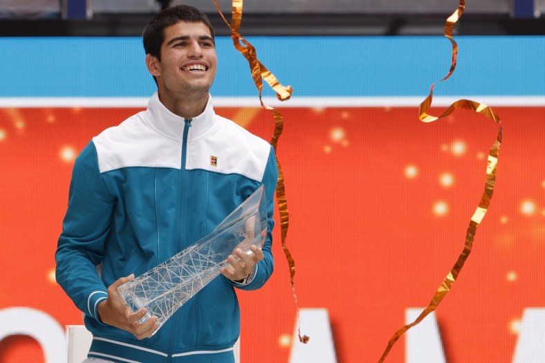 Apr 3, 2022; Miami Gardens, FL, USA; Carlos Alcaraz (ESP) celebrates with the Butch Buchholz Championship Trophy after his match against Casper Ruud (NOR)(not pictured) in the men's singles final in the Miami Open at Hard Rock Stadium. Mandatory Credit: Geoff Burke-USA TODAY Sports