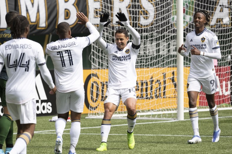 Apr 3, 2022; Portland, Oregon, USA; Los Angeles Galaxy forward Javier Hernandez (14) celebrates with midfielder Samuel Grandsir (11) after scoring a goal during the first half against the Portland Timbers at Providence Park. Mandatory Credit: Troy Wayrynen-USA TODAY Sports