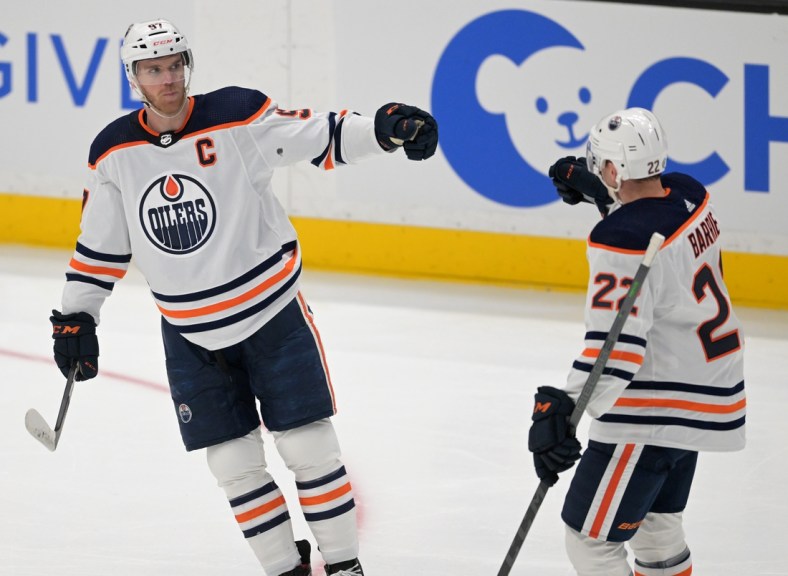 Apr 3, 2022; Anaheim, California, USA; Edmonton Oilers center Connor McDavid (97) is congratulated by defenseman Tyson Barrie (22) after scoring a goal in the first period of the game against the Anaheim Ducks at Honda Center. Mandatory Credit: Jayne Kamin-Oncea-USA TODAY Sports