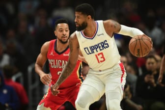 Apr 3, 2022; Los Angeles, California, USA; Los Angeles Clippers guard Paul George (13) controls the ball against New Orleans Pelicans guard CJ McCollum (3) during the first half at Crypto.com Arena. Mandatory Credit: Gary A. Vasquez-USA TODAY Sports
