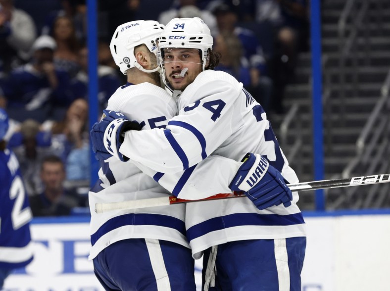 Apr 4, 2022; Tampa, Florida, USA; Toronto Maple Leafs center Auston Matthews (34) is congratulated by defenseman Mark Giordano (55) after he scored a goal against the Tampa Bay Lightning during the second period at Amalie Arena. Mandatory Credit: Kim Klement-USA TODAY Sports