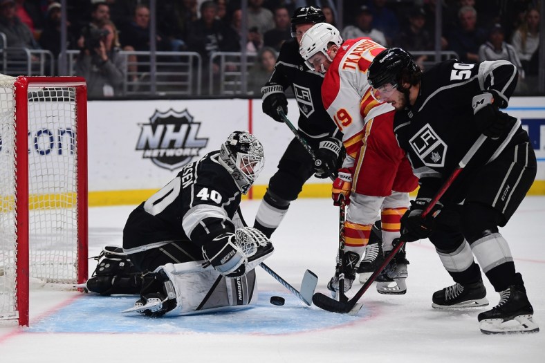 Apr 4, 2022; Los Angeles, California, USA; Calgary Flames left wing Matthew Tkachuk (19) moves in for a shot as Los Angeles Kings defenseman Sean Durzi (50) helps goaltender Cal Petersen (40) defend the goal during the first period at Crypto.com Arena. Mandatory Credit: Gary A. Vasquez-USA TODAY Sports