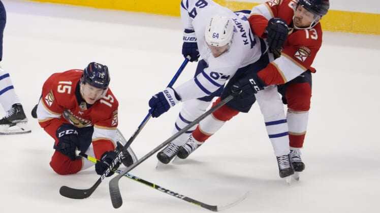Apr 5, 2022; Sunrise, Florida, USA; Florida Panthers center Anton Lundell (15) and center Sam Reinhart (13) battle Toronto Maple Leafs center David Kampf (64) for the puck during the first period at FLA Live Arena. Mandatory Credit: Jasen Vinlove-USA TODAY Sports