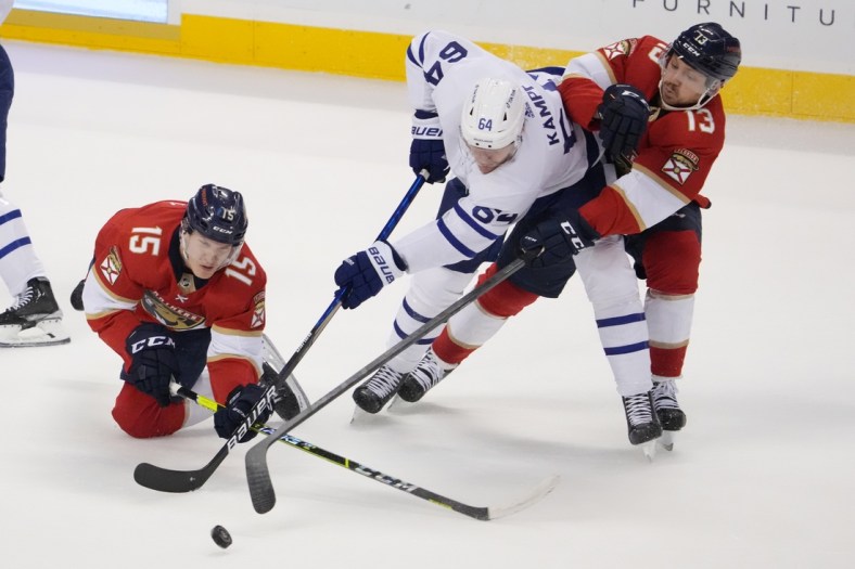 Apr 5, 2022; Sunrise, Florida, USA; Florida Panthers center Anton Lundell (15) and center Sam Reinhart (13) battle Toronto Maple Leafs center David Kampf (64) for the puck during the first period at FLA Live Arena. Mandatory Credit: Jasen Vinlove-USA TODAY Sports