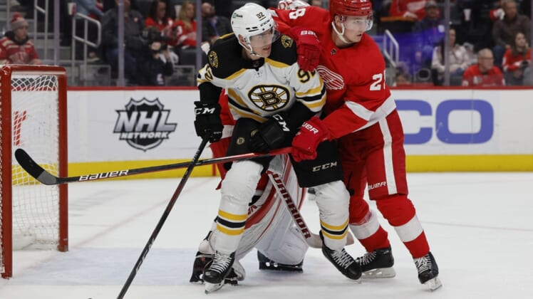 Apr 5, 2022; Detroit, Michigan, USA;  Boston Bruins left wing Tomas Nosek (92)ref10 and Detroit Red Wings defenseman Gustav Lindstrom (28) fight for position in front of goaltender Alex Nedeljkovic (39) in the first period at Little Caesars Arena. Mandatory Credit: Rick Osentoski-USA TODAY Sports
