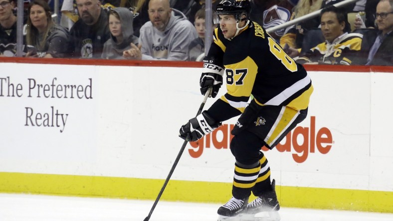 Apr 5, 2022; Pittsburgh, Pennsylvania, USA;  Pittsburgh Penguins center Sidney Crosby (87) handles the puck against the Colorado Avalanche during the second period at PPG Paints Arena. Colorado won 6-4. Mandatory Credit: Charles LeClaire-USA TODAY Sports