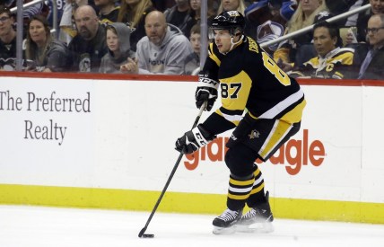 Apr 5, 2022; Pittsburgh, Pennsylvania, USA;  Pittsburgh Penguins center Sidney Crosby (87) handles the puck against the Colorado Avalanche during the second period at PPG Paints Arena. Colorado won 6-4. Mandatory Credit: Charles LeClaire-USA TODAY Sports
