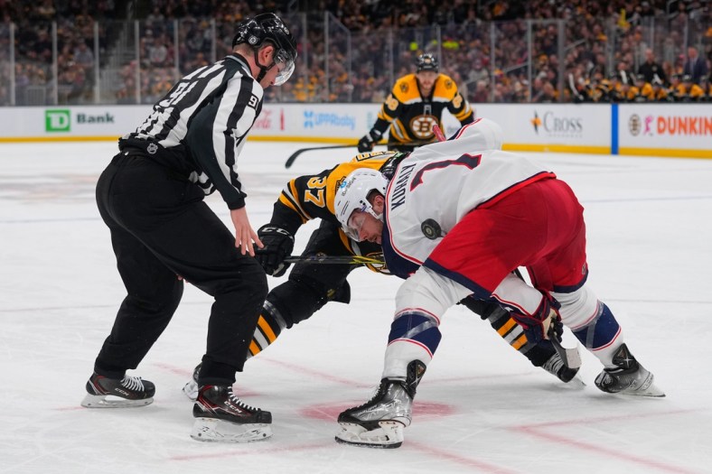 Apr 2, 2022; Boston, Massachusetts, USA; Boston Bruins center Patrice Bergeron (37) and Columbus Blue Jackets center Sean Kuraly (7) face off during the third period at TD Garden. Mandatory Credit: Gregory Fisher-USA TODAY Sports