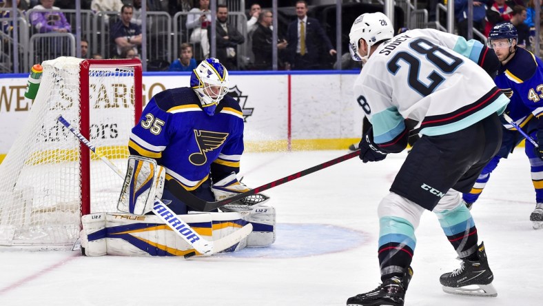 Apr 6, 2022; St. Louis, Missouri, USA;  St. Louis Blues goaltender Ville Husso (35) defends against Seattle Kraken defenseman Carson Soucy (28) during the third period at Enterprise Center. Mandatory Credit: Jeff Curry-USA TODAY Sports