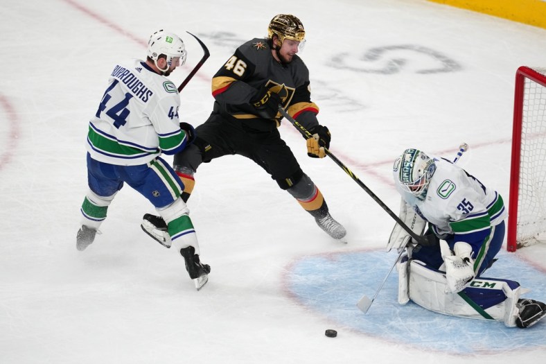 Apr 6, 2022; Las Vegas, Nevada, USA; Vancouver Canucks goaltender Thatcher Demko (35) makes a save against Vegas Golden Knights right wing Jonas Rondbjerg (46) as Vancouver Canucks defenseman Kyle Burroughs (44) joins the play during the third period at T-Mobile Arena. Mandatory Credit: Stephen R. Sylvanie-USA TODAY Sports