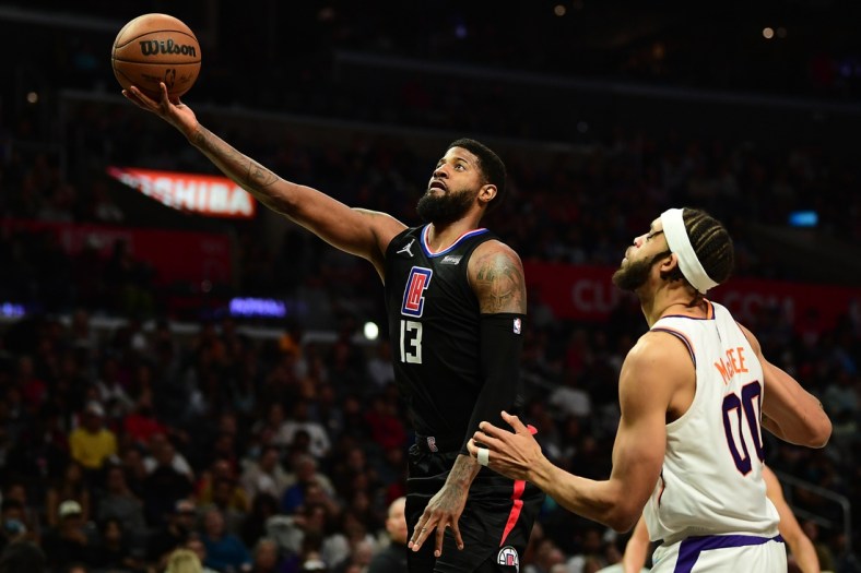 Apr 6, 2022; Los Angeles, California, USA; Los Angeles Clippers guard Paul George (13) shoots ahead of Phoenix Suns center JaVale McGee (00)  during the second half at Crypto.com Arena. Mandatory Credit: Gary A. Vasquez-USA TODAY Sports