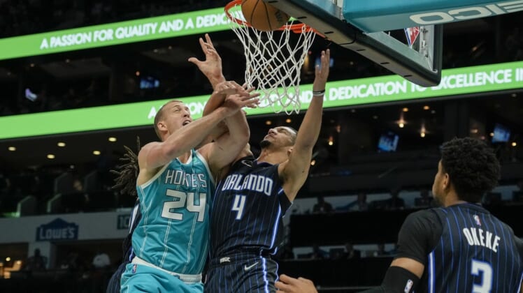 Apr 7, 2022; Charlotte, North Carolina, USA; Charlotte Hornets center Mason Plumlee (24) gets fouled on his shot attempt by Orlando Magic guard Jalen Suggs (4) during the first quarter at Spectrum Center. Mandatory Credit: Jim Dedmon-USA TODAY Sports
