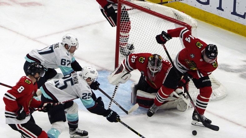 Apr 7, 2022; Chicago, Illinois, USA; Chicago Blackhawks left wing Boris Katchouk (14) clears the puck against the Seattle Kraken during the first period at United Center. Mandatory Credit: David Banks-USA TODAY Sports