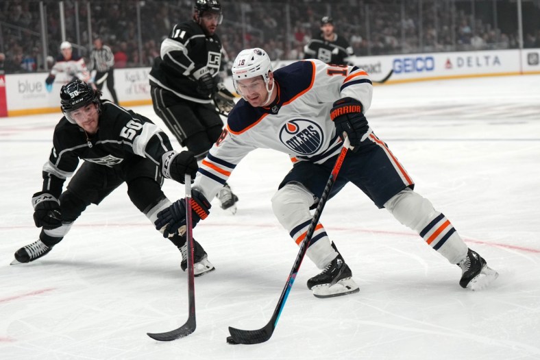 Apr 7, 2022; Los Angeles, California, USA; Edmonton Oilers left wing Zach Hyman (18) and LA Kings defenseman Sean Durzi (50) battle for the puck in the first period at Crypto.com Arena. Mandatory Credit: Kirby Lee-USA TODAY Sports