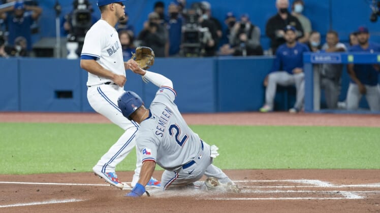 Apr 8, 2022; Toronto, Ontario, CAN; Texas Rangers second baseman Marcus Semien (2) scores a run on a wild pitch during the first inning against the Toronto Blue Jays at Rogers Centre . Mandatory Credit: Nick Turchiaro-USA TODAY Sports