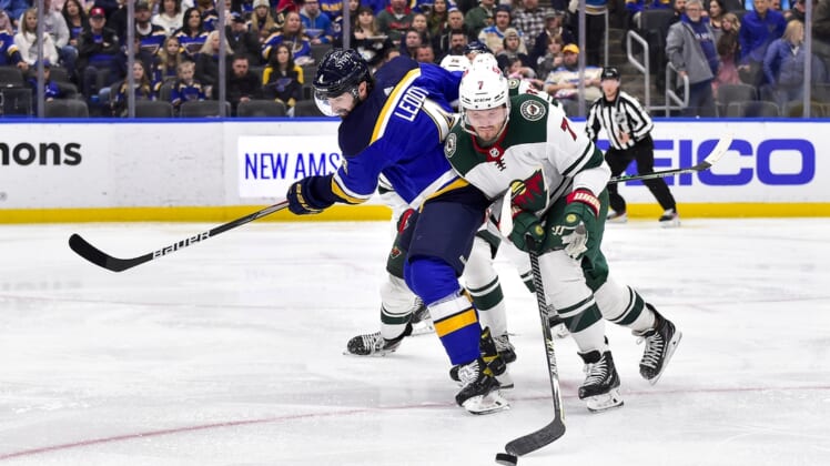 Apr 8, 2022; St. Louis, Missouri, USA;  St. Louis Blues defenseman Nick Leddy (4) and Minnesota Wild defenseman Dmitry Kulikov (7) battle for the puck during the second period at Enterprise Center. Mandatory Credit: Jeff Curry-USA TODAY Sports