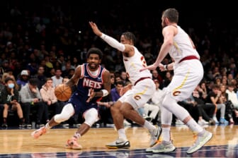 Apr 8, 2022; Brooklyn, New York, USA; Brooklyn Nets guard Kyrie Irving (11) drives to the basket against Cleveland Cavaliers forward Isaac Okoro (35) and forward Kevin Love (0) during the third quarter at Barclays Center. Mandatory Credit: Brad Penner-USA TODAY Sports