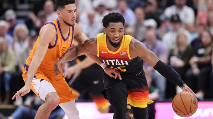 Apr 8, 2022; Salt Lake City, Utah, USA; Utah Jazz guard Donovan Mitchell (45) bring the ball up the court defended by Phoenix Suns guard Devin Booker (1) in the second quarter at Vivint Arena. Mandatory Credit: Rob Gray-USA TODAY Sports