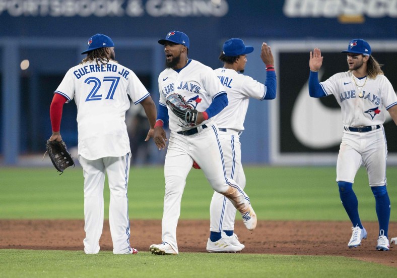Apr 8, 2022; Toronto, Ontario, CAN; Toronto Blue Jays right fielder Teoscar Hernandez (37) and first baseman Vladimir Guerrero Jr. (27) celebrate the win at the end of the ninth inning against the Texas Rangers at Rogers Centre . Mandatory Credit: Nick Turchiaro-USA TODAY Sports