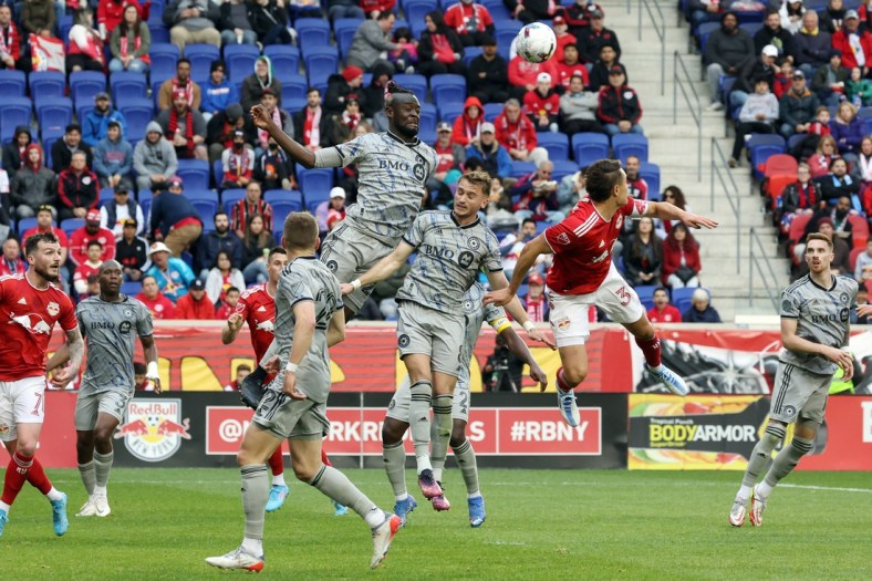 Apr 9, 2022; Harrison, New Jersey, USA; New York Red Bulls midfielder Aaron Long (33) and CF Montreal midfielder Djordje Mihailovic (8) and forward Kei Kamara (23) jump for a header in the second half at Red Bull Arena. Mandatory Credit: Vincent Carchietta-USA TODAY Sports