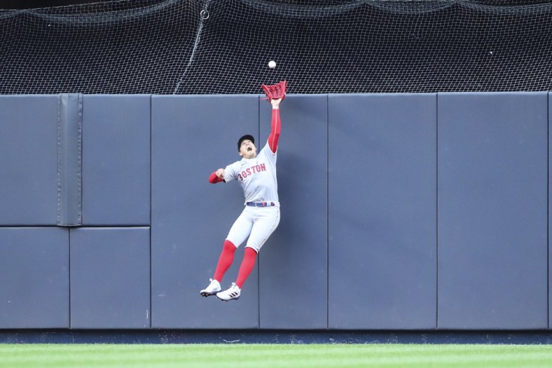 Apr 9, 2022; Bronx, New York, USA;  Boston Red Sox center fielder Enrique Hernandez (5) makes a leaping catch in the fourth inning against the New York Yankees at Yankee Stadium. Mandatory Credit: Wendell Cruz-USA TODAY Sports