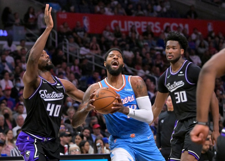 Apr 9, 2022; Los Angeles, California, USA;  Los Angeles Clippers guard Paul George (13) drives to the basket against  Sacramento Kings forward Harrison Barnes (40) and center Damian Jones (30) during the first half at Crypto.com Arena. Mandatory Credit: Jayne Kamin-Oncea-USA TODAY Sports
