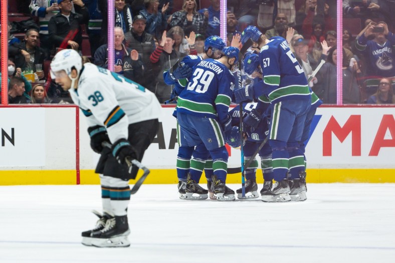 Apr 9, 2022; Vancouver, British Columbia, CAN;  Vancouver Canucks right wing Conor Garland (8) is congratulated after scoring a goal as San Jose Sharks defenseman Mario Ferraro (38) skates on in the second period at Rogers Arena. Mandatory Credit: Derek Cain-USA TODAY Sports