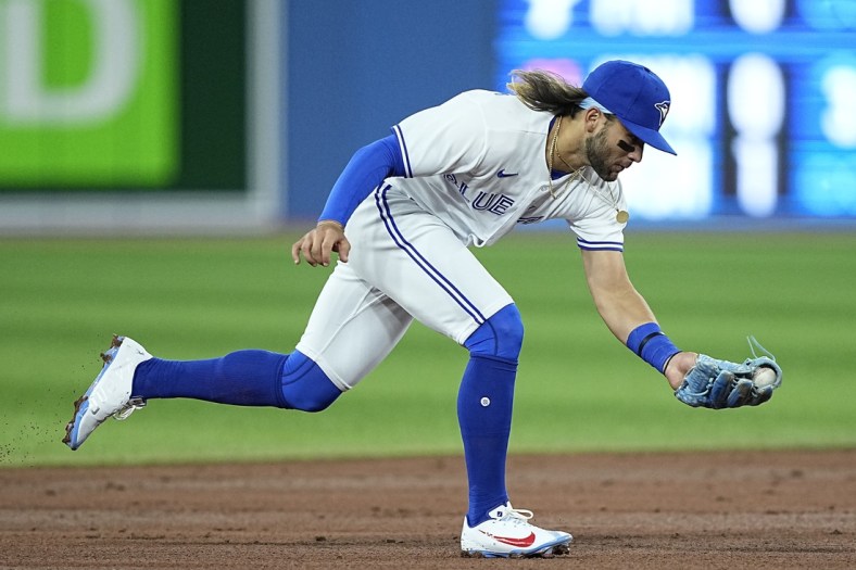Apr 10, 2022; Toronto, Ontario, CAN; Toronto Blue Jays shortstop Bo Bichette (11) fields a ground ball hit by Texas Rangers baseman Charlie Culberson (not pictured) during the second inning at Rogers Centre. Mandatory Credit: John E. Sokolowski-USA TODAY Sports