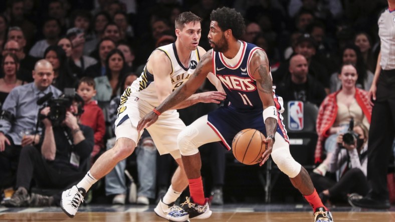 Apr 10, 2022; Brooklyn, New York, USA;  Brooklyn Nets guard Kyrie Irving (11) looks to drive past Indiana Pacers guard T.J. McConnell (9) in the first quarter at Barclays Center. Mandatory Credit: Wendell Cruz-USA TODAY Sports