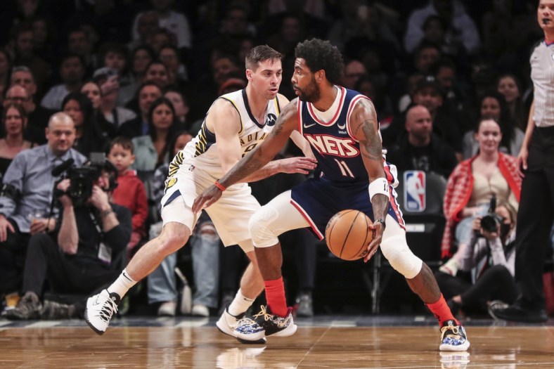 Apr 10, 2022; Brooklyn, New York, USA;  Brooklyn Nets guard Kyrie Irving (11) looks to drive past Indiana Pacers guard T.J. McConnell (9) in the first quarter at Barclays Center. Mandatory Credit: Wendell Cruz-USA TODAY Sports