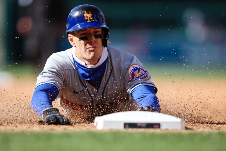 Apr 10, 2022; Washington, District of Columbia, USA; New York Mets right fielder Mark Canha (19) slides into first base against the Washington Nationals during the ninth inning at Nationals Park. Mandatory Credit: Scott Taetsch-USA TODAY Sports