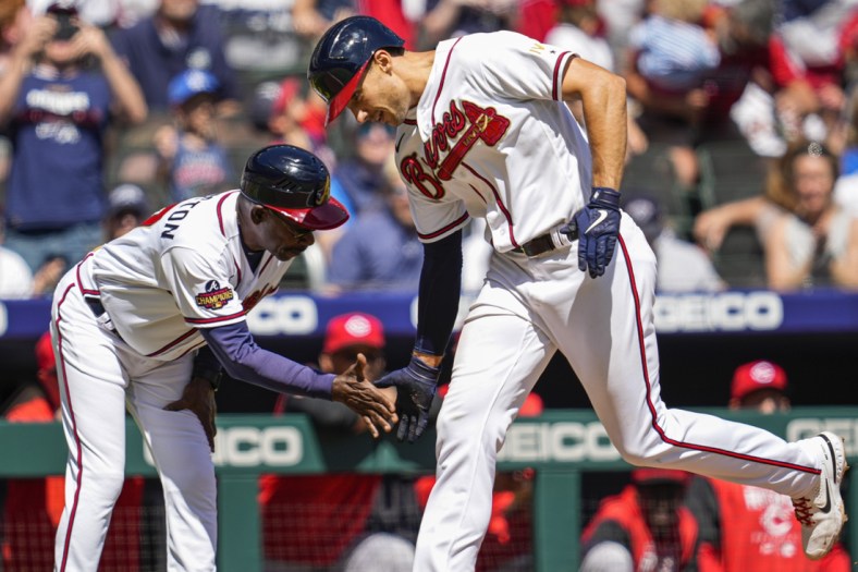 Apr 10, 2022; Cumberland, Georgia, USA; Atlanta Braves first baseman Matt Olson (28) (right) reacts with third base coach Ron Washington (37) after hitting a home run against the Cincinnati Reds during the fifth inning at Truist Park. Mandatory Credit: Dale Zanine-USA TODAY Sports