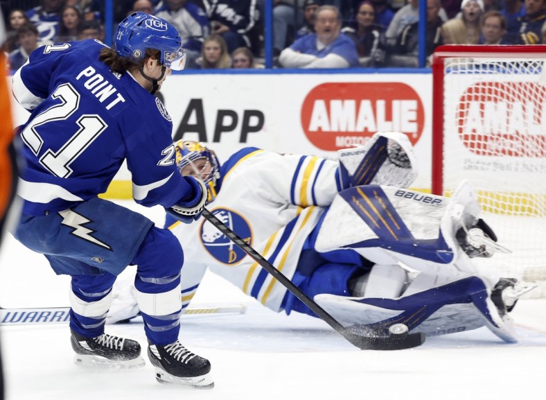 Apr 10, 2022; Tampa, Florida, USA;Tampa Bay Lightning center Brayden Point (21) shoots on goal as Buffalo Sabres goaltender Craig Anderson (41) makes a save  during the first period at Amalie Arena. Mandatory Credit: Kim Klement-USA TODAY Sports