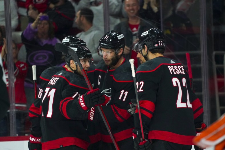 Apr 10, 2022; Raleigh, North Carolina, USA;  Carolina Hurricanes center Jordan Staal (11) is congratulated by  defenseman Brett Pesce (22) and right wing Jesper Fast (71) after his goal against the Anaheim Ducks during the first period at PNC Arena. Mandatory Credit: James Guillory-USA TODAY Sports