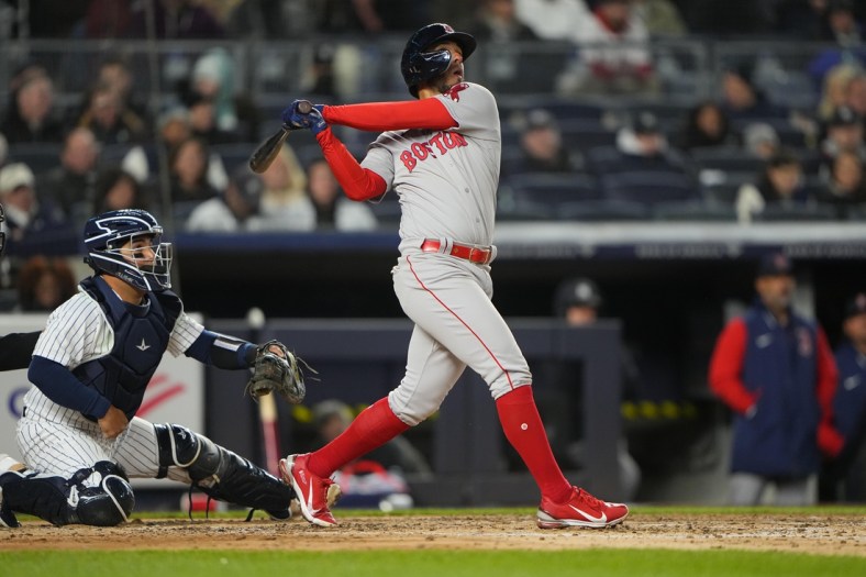 Apr 10, 2022; Bronx, New York, USA; Boston Red Sox second baseman Jonathan Arauz (3) hits a sacrifice fly ball against the New York Yankees during the fourth inning at Yankee Stadium. Mandatory Credit: Gregory Fisher-USA TODAY Sports