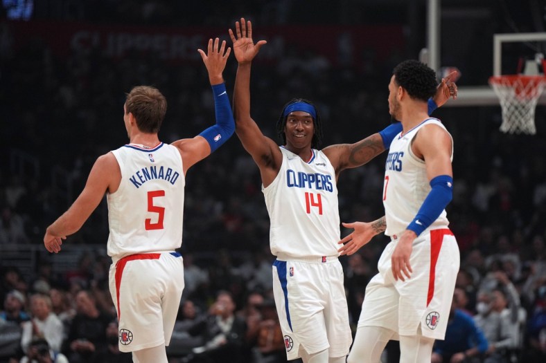 Apr 10, 2022; Los Angeles, California, USA; LA Clippers guard Luke Kennard (5), guard Terance Mann (14) and guard Amir Coffey (7) celebrate in the first half against the Oklahoma City Thunder at Crypto.com Arena. Mandatory Credit: Kirby Lee-USA TODAY Sports