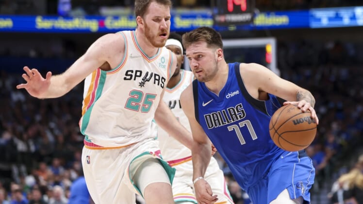 Apr 10, 2022; Dallas, Texas, USA;  Dallas Mavericks guard Luka Doncic (77) drives to the basket past San Antonio Spurs center Jakob Poeltl (25) during the second quarter at American Airlines Center. Mandatory Credit: Kevin Jairaj-USA TODAY Sports