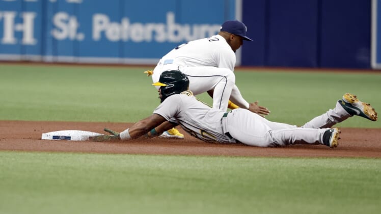 Apr 11, 2022; St. Petersburg, Florida, USA; Oakland Athletics shortstop Elvis Andrus (17) slides into second base after hitting a double ahead of the throw to Tampa Bay Rays shortstop Wander Franco (5) during the first inning at Tropicana Field. Mandatory Credit: Kim Klement-USA TODAY Sports